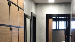 A hallway with wooden flooring and a mirrored wardrobe with black handles. - Hostel Boulevard Prishtina (Pristina)