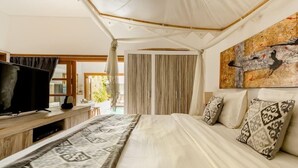 A bedroom with a bed, a TV, curtains, and a painting. - 2 Bedroom Villa in Seminyak Bali with private pool and enclosed Living Room. (Seminyak)