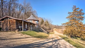 A rustic cabin with a sloped roof, a porch, and a dirt driveway leading to a gravel path. - Rustic Iowa Cabin: 10 Mi to Maquoketa Caves (Spragueville)