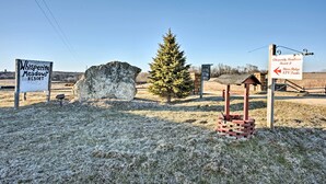 A sign for Whispering Meadows Resort with a rustic birdhouse and a large rock. - Rustic Iowa Cabin: 10 Mi to Maquoketa Caves (Spragueville)