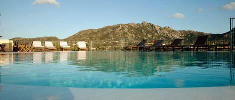 Piscine extérieure en saison, parasols, chaises longues