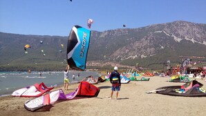 A beach with people flying kites and windsurfing. - No 22 Hotel Riders' Inn (Ula)