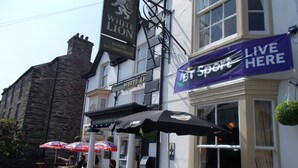 A pub named "White Lion" with outdoor seating and a "Live Here" banner. - The White Lion Hotel (Machynlleth)