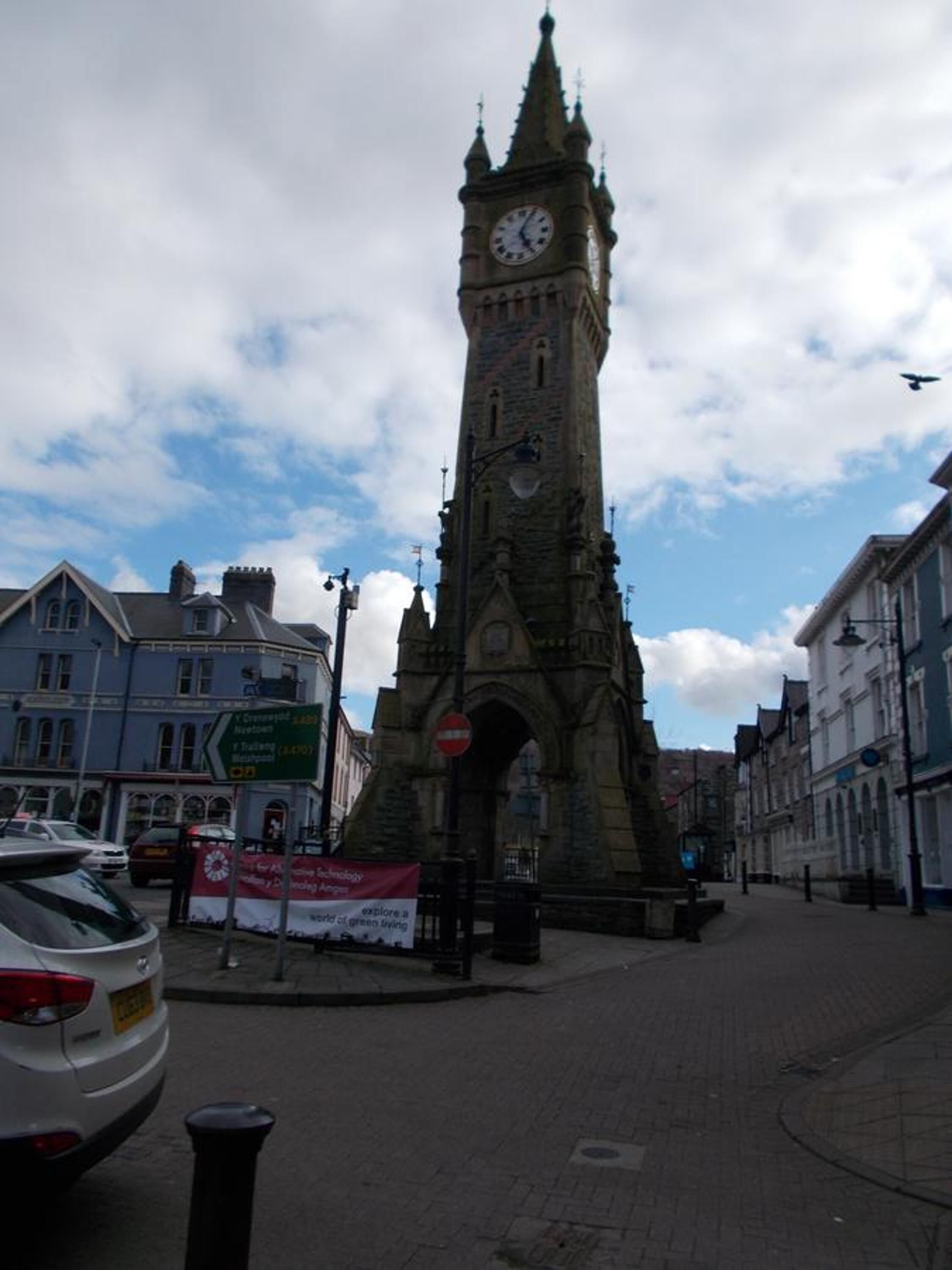 A historic clock tower with a clock face, surrounded by traditional architecture and a clear sky.