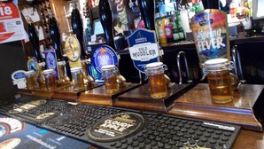 A bar with multiple beer taps and a variety of bottles in the background. - The White Lion Hotel (Machynlleth)