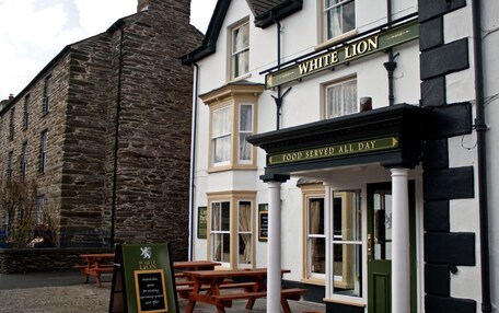 A traditional pub named "White Lion" with a sign stating "Food Served All Day."