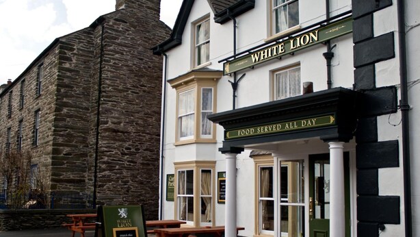 A traditional pub named "White Lion" with a sign stating "Food Served All Day." - The White Lion Hotel (Machynlleth)