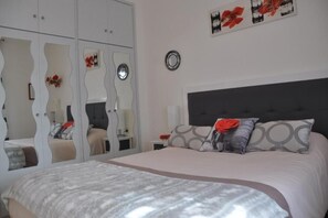 2 dormitorios y tabla de planchar con plancha