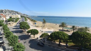 Eine Küstenstadt mit Strand, Palmen und blauem Himmel.