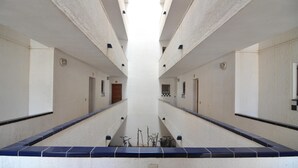A long, narrow corridor with tiled walls and a central walkway. - Vacation rental in Roses, Costa Brava: Cozy apartment 400 meters from the beach, capacity for 4 people, with terrace and amenities. (Rosas / Roses)