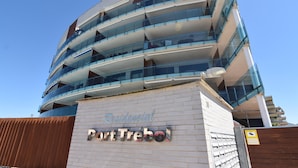 A multi-story residential building with a modern design, featuring balconies and large windows.