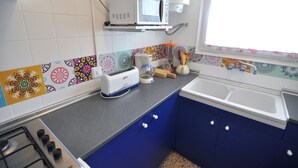 Uma cozinha com micro-ondas, torradeira e pia.