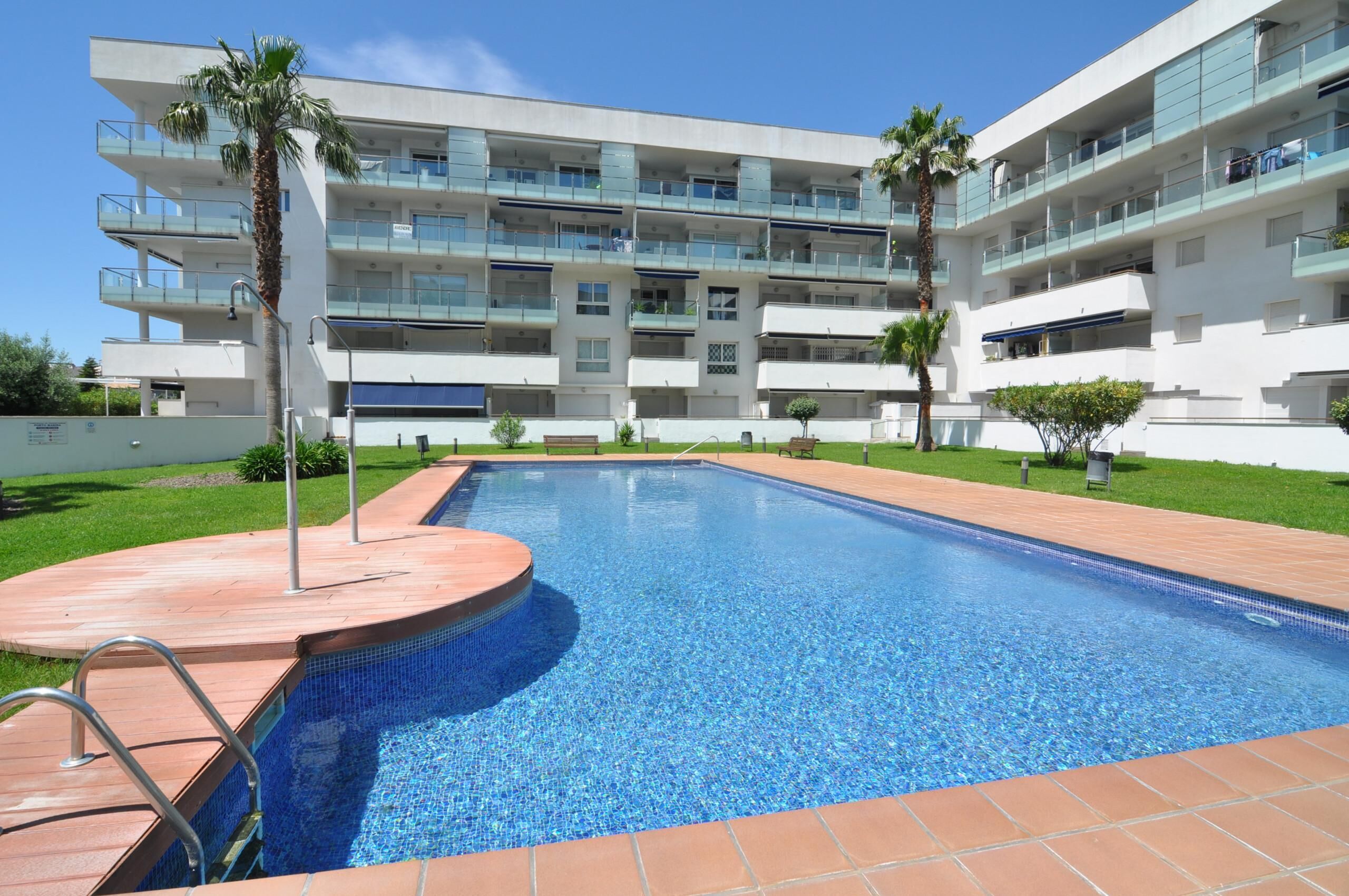Un hôtel moderne doté d’une piscine, de nombreux balcons et d’une pelouse bien entretenue.