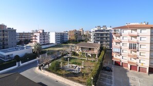 Ett bostadsområde med flerfamiljshus, en central innergård med en fontän och en parkeringsplats.