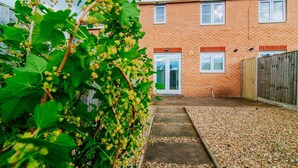 A brick house with a gravel driveway and a wooden fence. - Harris House (Doncaster)