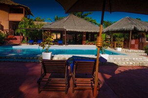 Una piscina al aire libre, tumbonas