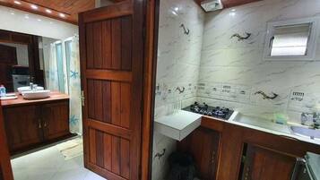 Cocina con armarios de madera, encimera blanca y salpicadero de azulejos.