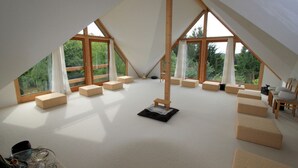 A spacious attic room with large windows, wooden beams, and multiple seating areas. - Landhaus Lichthof (Lohmar)