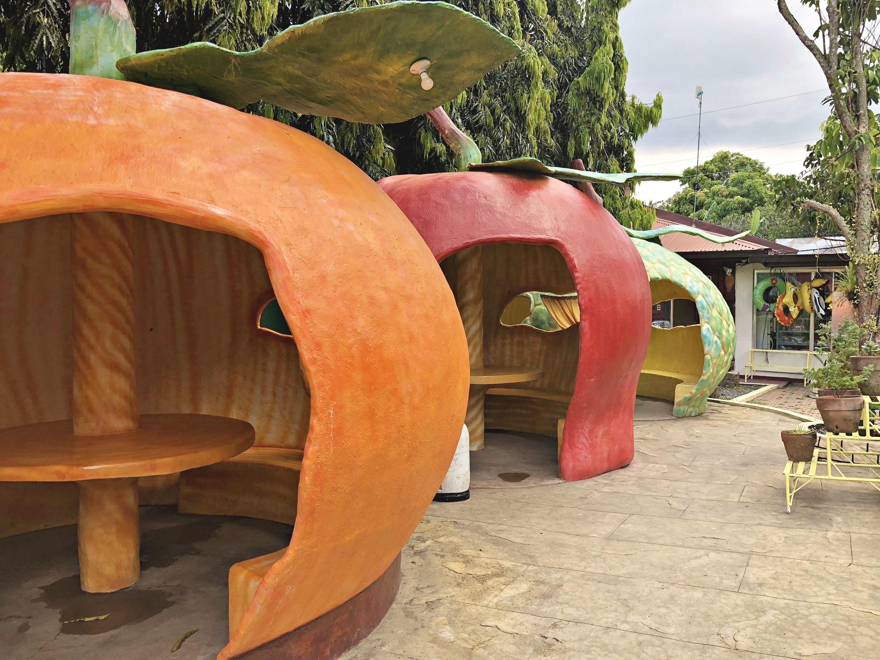 A row of uniquely designed treehouse-like structures with circular openings, likely serving as private rooms or cabins.
