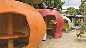 A row of uniquely designed treehouse-like structures with circular openings, likely serving as private rooms or cabins.