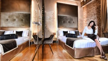 A hotel room with two beds, a sitting area with a chair, and a large mirror.