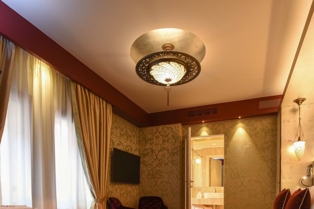 Une chambre d’hôtel avec un lit, un bureau, une chaise, une télévision et une salle de bain visible à travers une porte ouverte.