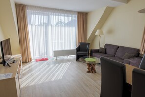 Apartamento, 2 quartos | Área de estar | TV de tela plana 25 polegadas com canais via satélite