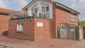 A two-story brick building with a balcony, a sign reading "Boardinghouse," and a gated entrance. - Boardinghouse Büsum (Büsum)