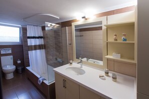 Luxe appartement | Badkamer | Een bad, gratis toiletartikelen, een haardroger, handdoeken
