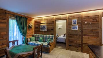 A cozy room with a wooden interior, a bed, a sofa, and a dining area.
