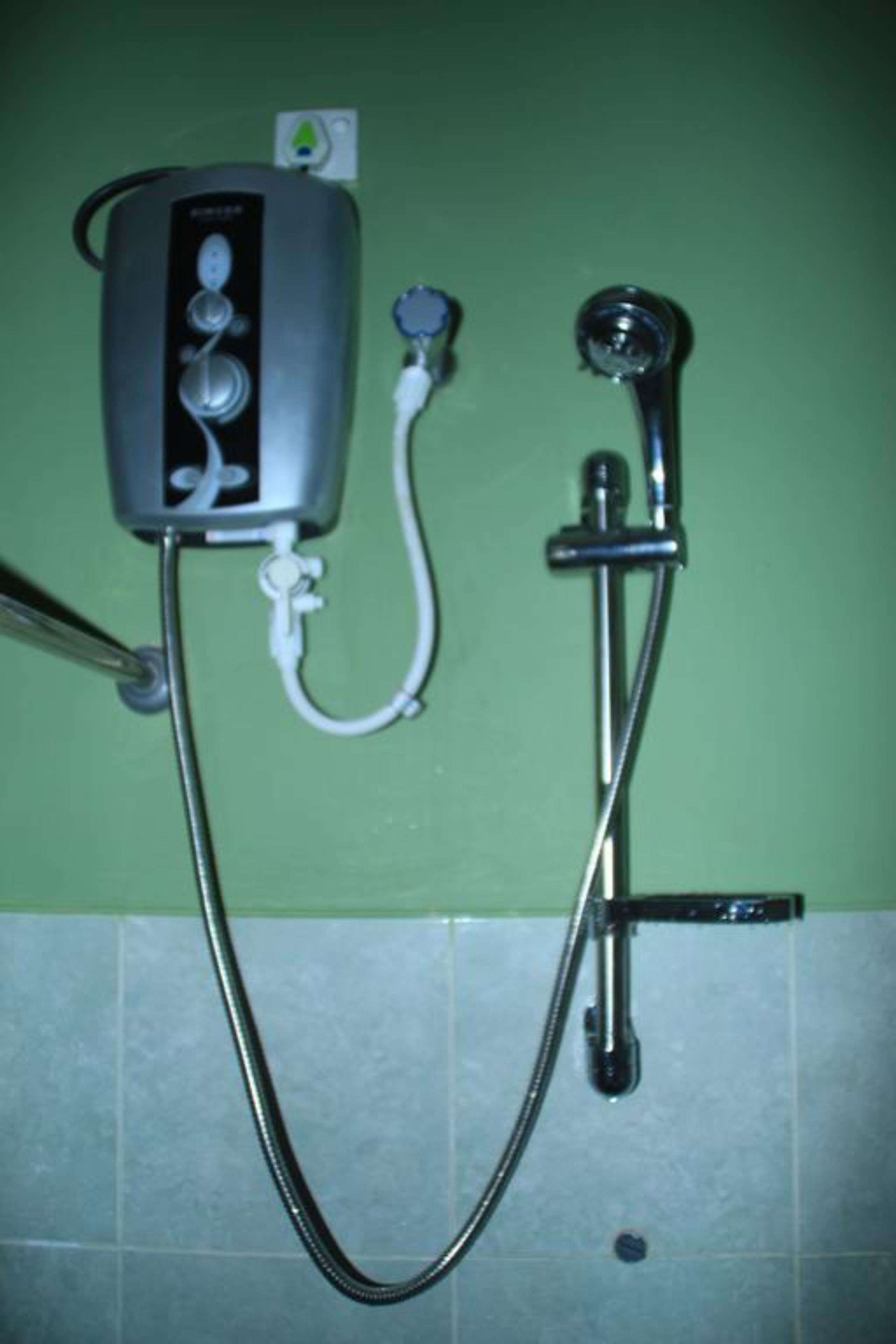 A shower setup with a handheld showerhead and a wall-mounted control panel.