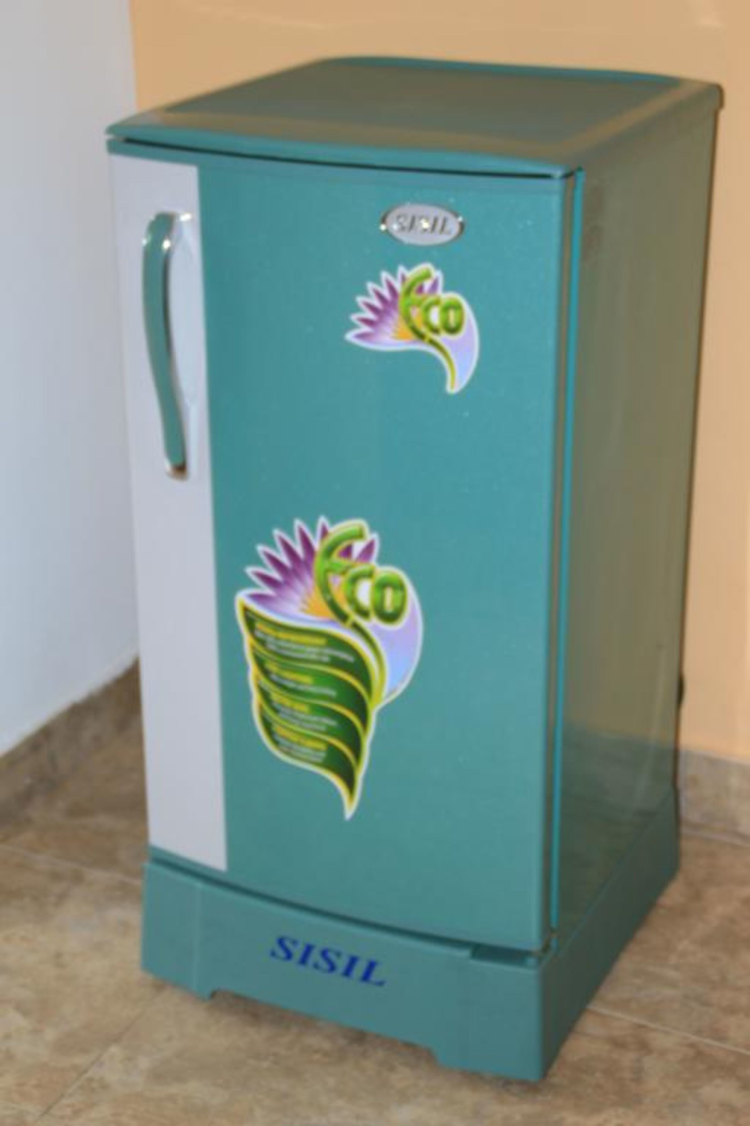 Un refrigerador color turquesa con un asa en el lado izquierdo y un adhesivo de una planta en la parte frontal.