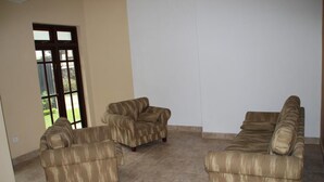 A living room with three sofas and a large window. - Selfcate Luxury Apartments (Kandy)