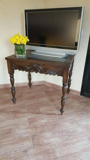 A wooden table with a flat surface and turned legs, placed on a tiled floor. - Perla Maya Hotel (Panajachel)