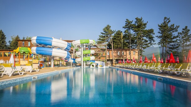 A swimming pool with water slides and lounge chairs. - Hotel Elbrus SPA & Wellness (Velingrad)