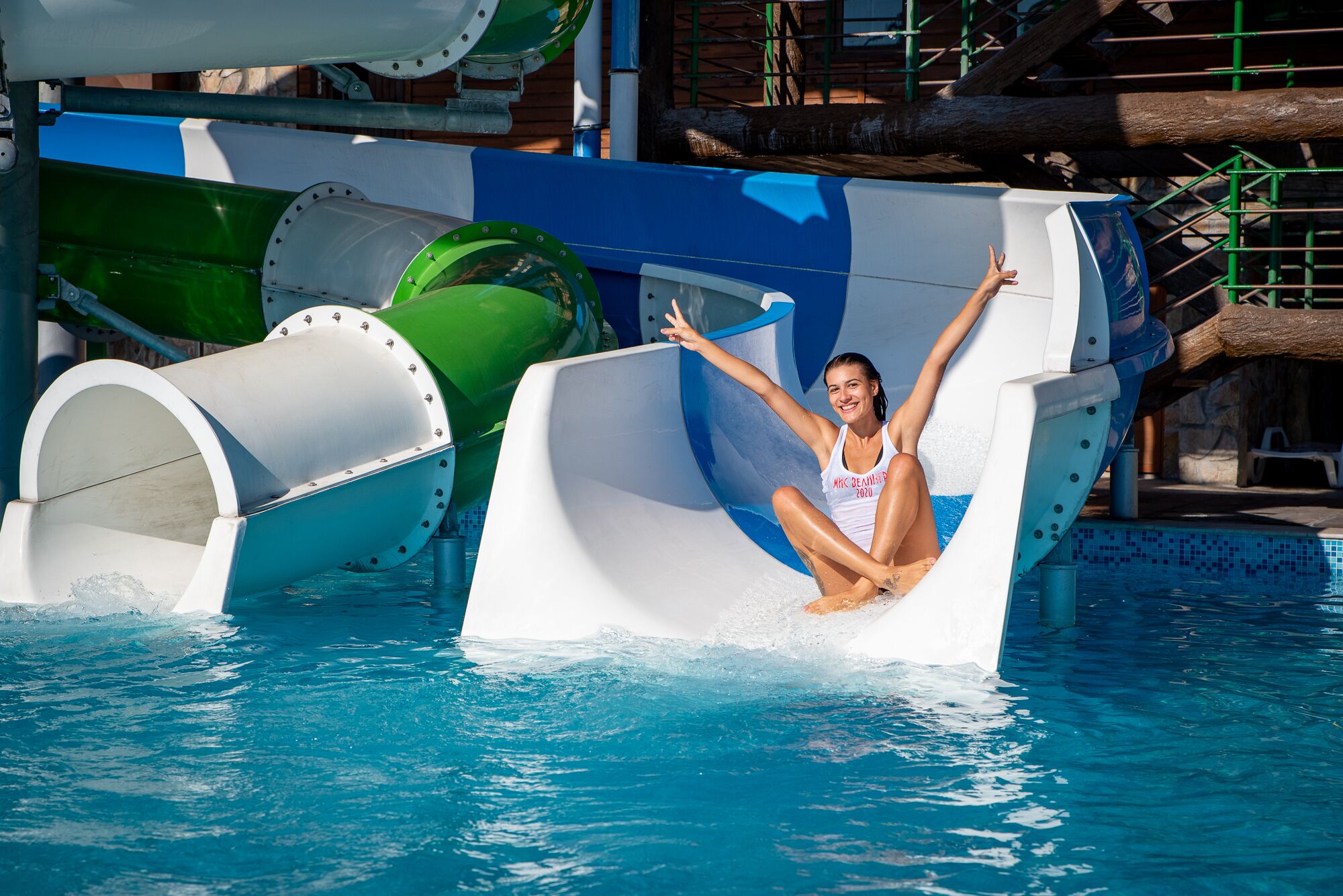 A water slide with a person sliding down into a pool.
