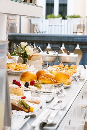 A buffet with various food items, including pastries, sandwiches, and a selection of beverages. - Antica Dimora Magi (Sorrento)