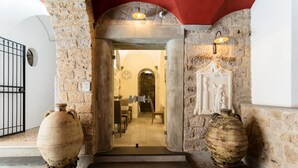 A stone entrance with two large vases, a red ceiling, and a view into a dining area. - Antica Dimora Magi (Sorrento)