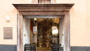 A stone entrance with a metal gate, a plaque, and a stone wall. - Antica Dimora Magi (Sorrento)
