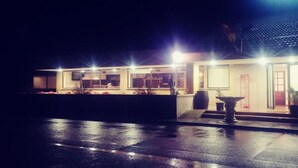 Een hotel met een moderne gevel, meerdere verlichte ramen en een goed verlichte entree.