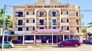 Um hotel com vários andares, varandas e um restaurante chamado "Restaurante Maria Eugenia" no térreo.