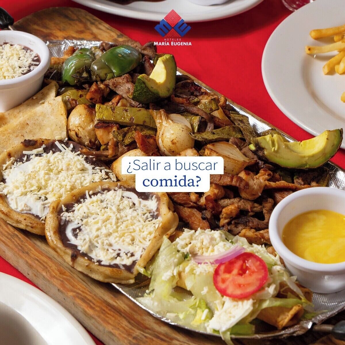 Variedad de platillos, incluyendo tacos, una ensalada y papas fritas.