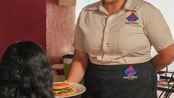 A hotel staff member serving a meal to a guest.