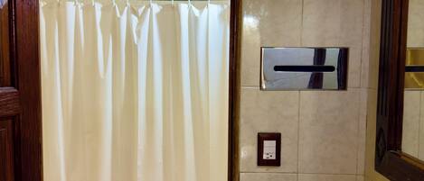 A bathroom with a shower curtain, a toilet, and a sink with floral designs.