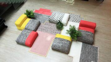 Une pièce avec un plancher en bois, un ensemble de meubles de salon et une petite plante.