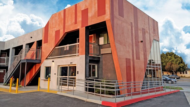 A modern building with a unique angular design, featuring multiple balconies and a staircase. - Epic Hotel (Pico Rivera)