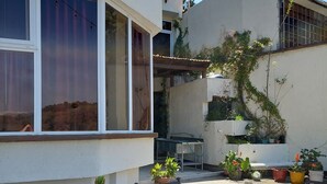 A patio area with a round table and chairs, surrounded by potted plants. - Aurora Express (Guatemala City)