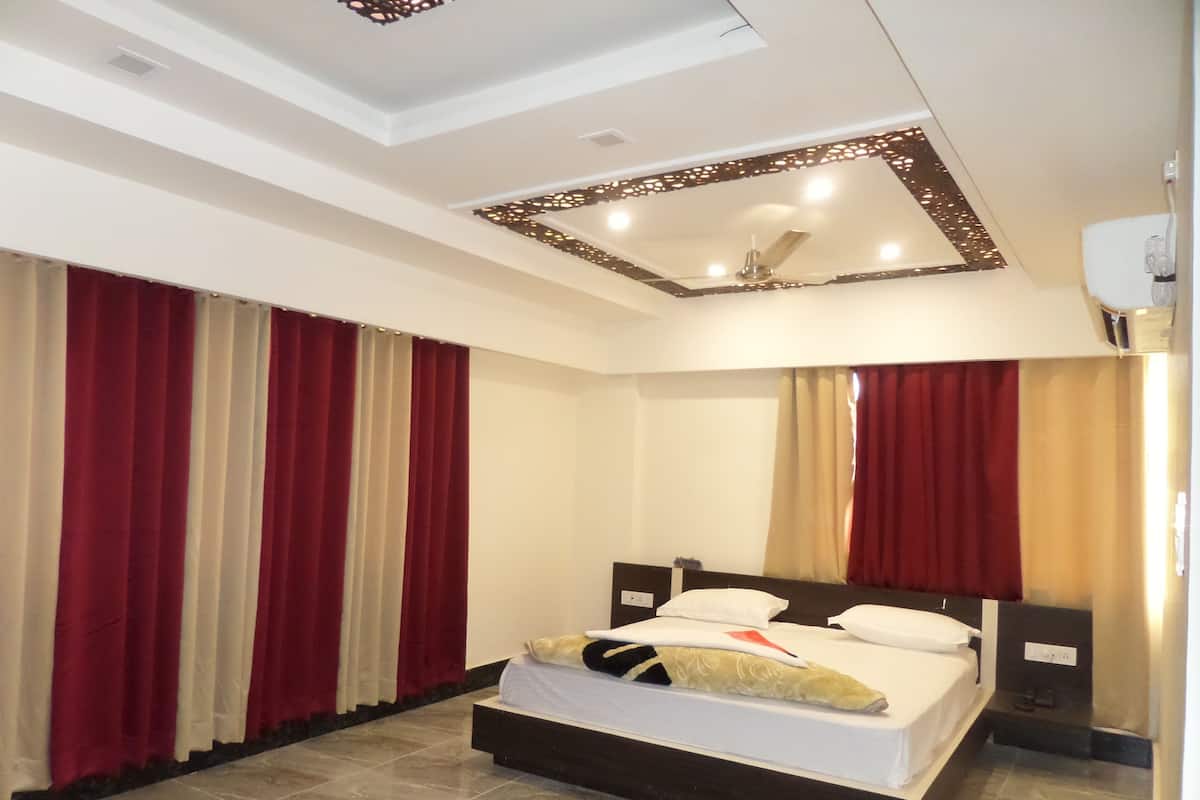 Habitación de hotel con una cama grande, ventilador de techo y diseño moderno.