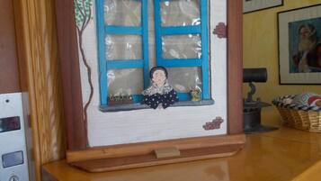 A wooden cabinet with a window display featuring a miniature scene with a figure and decorative elements.