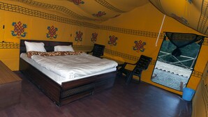 Een slaapkamer met een groot bed, een stoel en een raam met uitzicht op een gebouw.